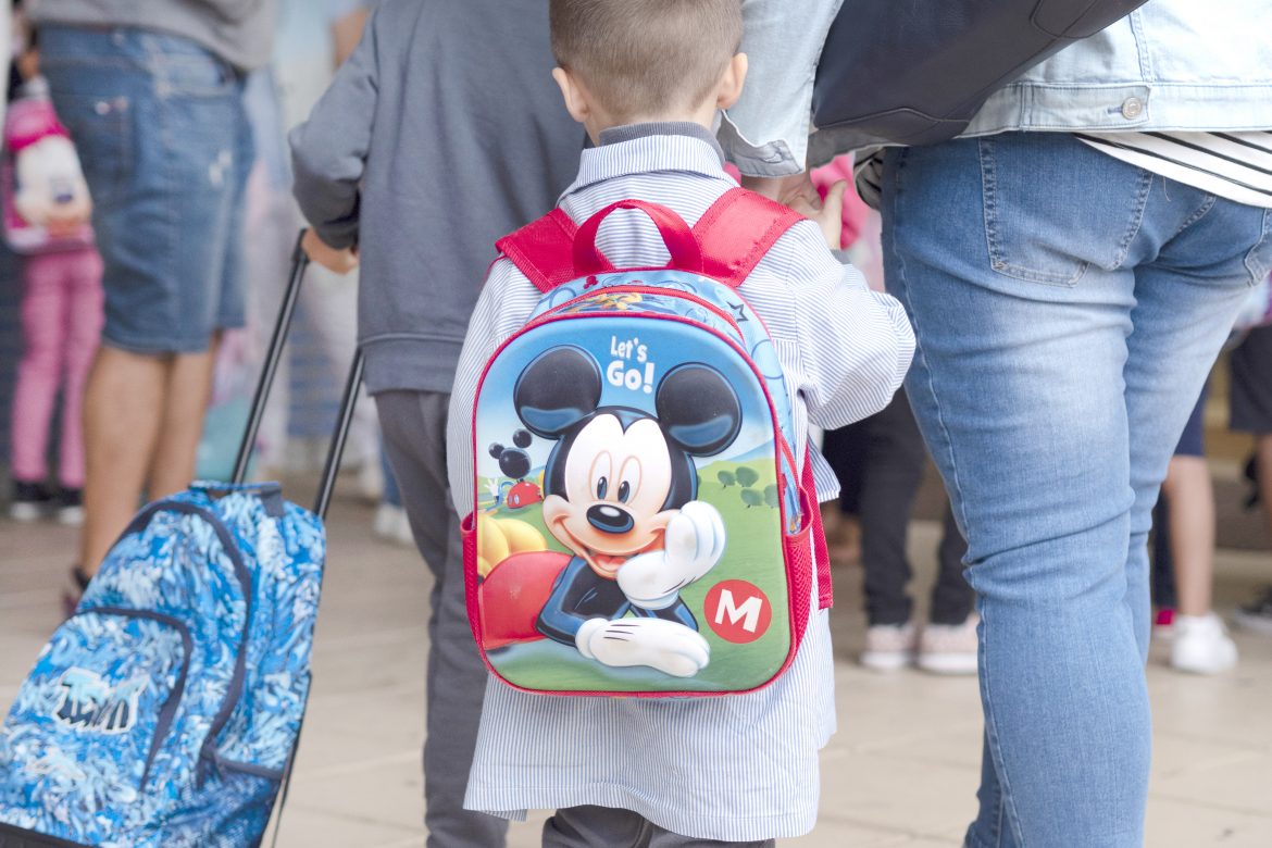 Un menor, de espaldas y de la mano de su madre. ENA