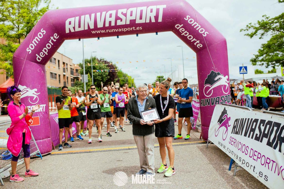 Blanca entrega la placa a Tomás bajo la atenta mirada de Mer y los aplausos del público. MUARÉ