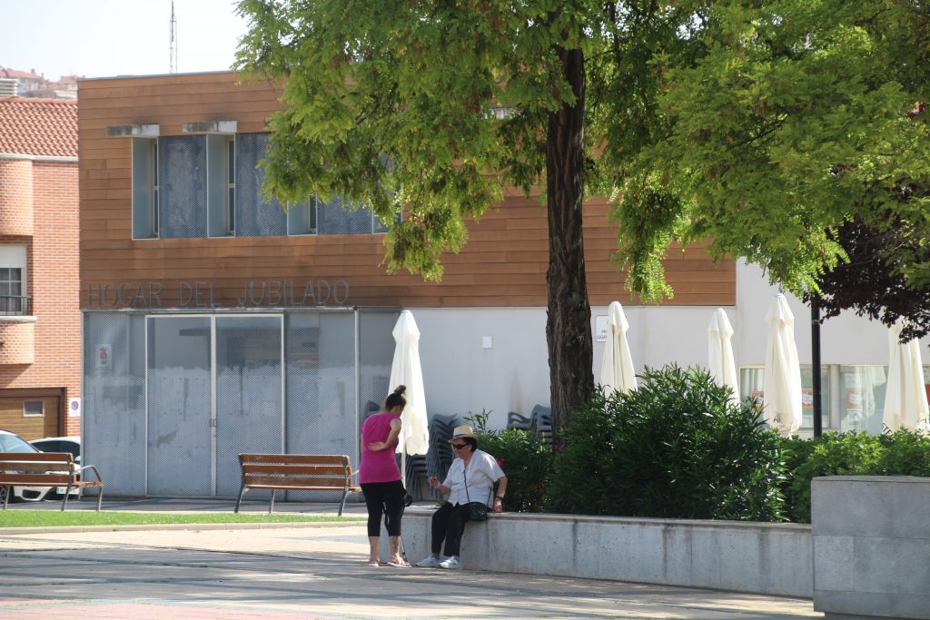 Dos personas sentadas bajo la sombra en la Plaza España de Arroyo de la Encomienda. ENA